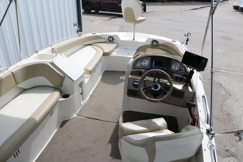Slide: The Image of 2015 Stingray 192 SC boat interior with beige seating and modern dashboard. - 19