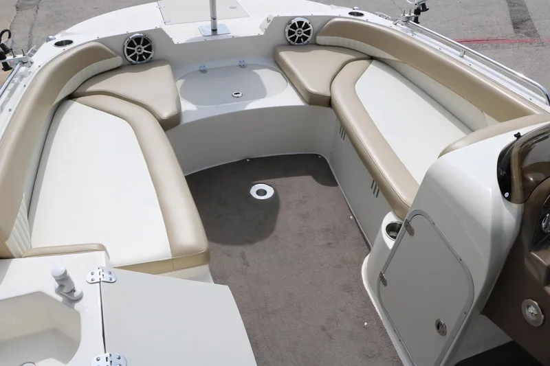 Slide: The Image of 2015 Stingray 192 SC boat interior with beige seating and carpeted floor. - 22