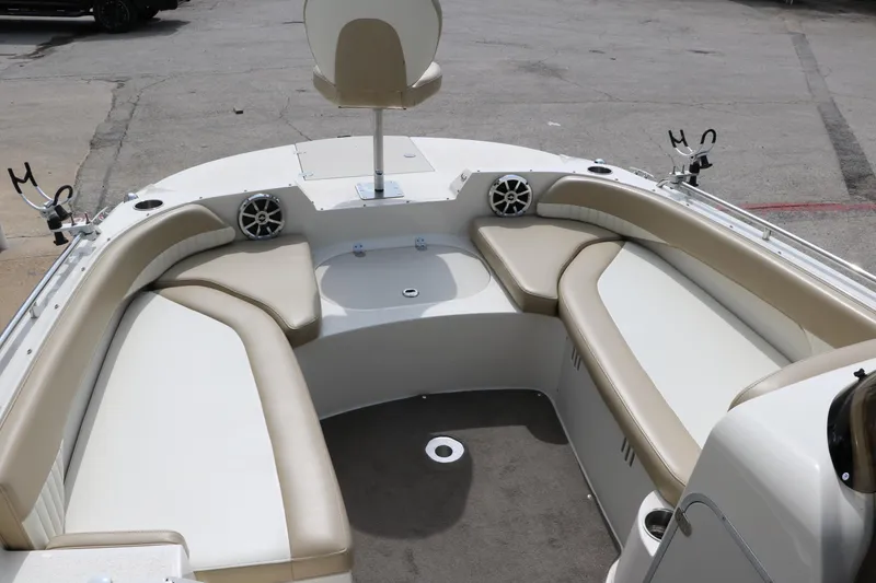 Slide: The Image of 2015 Stingray 192 SC boat interior with beige seating and fishing rod holders. - 23