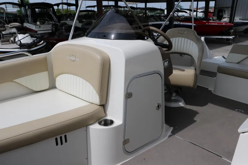 Slide: The Image of 2015 Stingray 192 SC boat interior with beige seating and steering console. - 28
