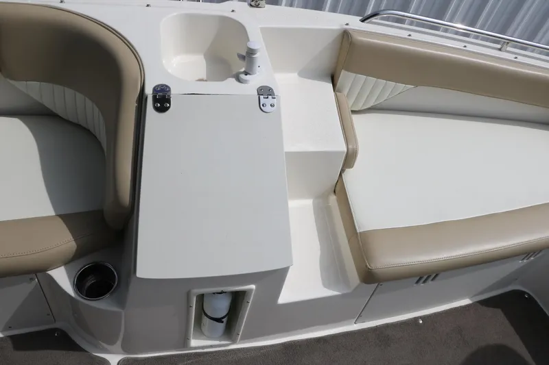 Slide: The Image of Interior of a 2015 Stingray 192 SC boat with beige seating and a small sink. - 30