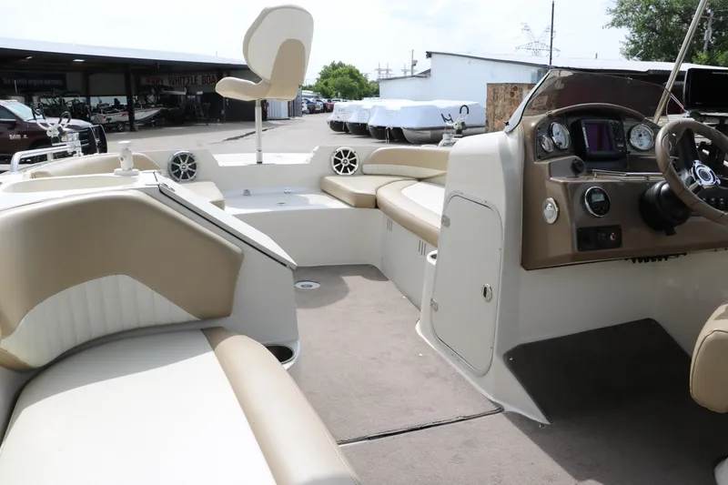 Slide: The Image of 2015 Stingray 192 SC boat interior with beige seating and modern dashboard. - 32