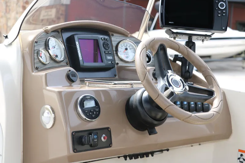 Slide: The Image of Dashboard of a 2015 Stingray 192 SC boat with steering wheel and navigation controls. - 34