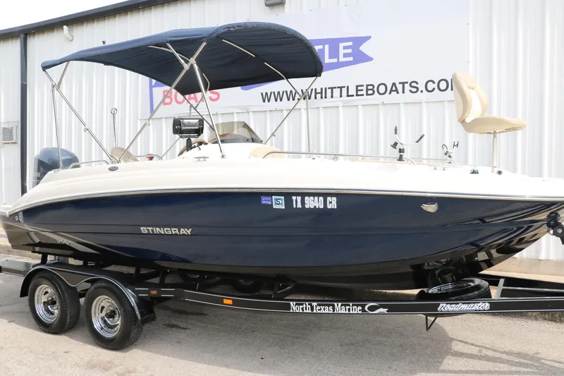 Slide: The Image of 2015 Stingray 192 SC boat on trailer, blue and white, with canopy, at North Texas Marine. - 4