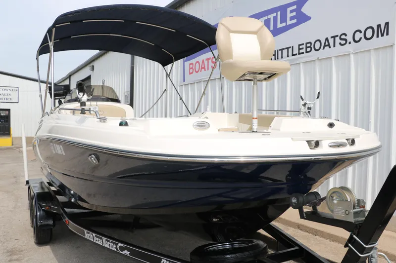 Slide: The Image of 2015 Stingray 192 SC boat on trailer with canopy, displayed at dealership. - 6