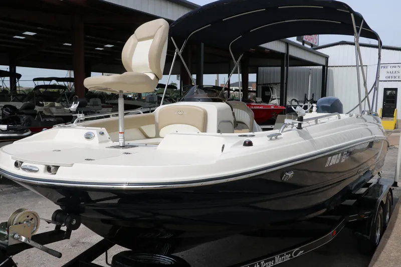 Slide: The Image of 2015 Stingray 192 SC boat with canopy, displayed at a marina. - 7