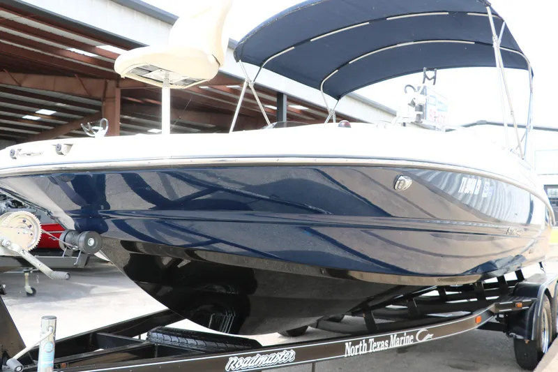 Slide: The Image of 2015 Stingray 192 SC boat with blue hull and canopy on trailer. - 8