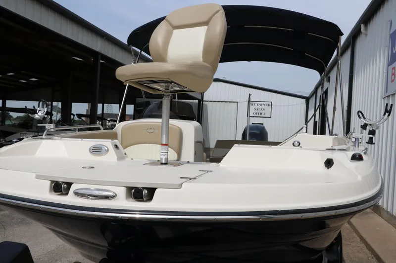 Slide: The Image of 2015 Stingray 192 SC boat with seating, docked in a covered marina area. - 9