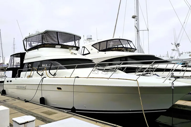The Image of 1995 Silverton 46 yacht docked at marina, showcasing sleek design and spacious deck. - 0