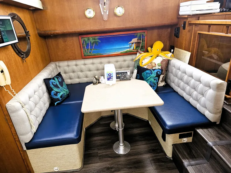 Slide: The Image of Cozy 1995 Silverton 46 yacht interior with plush seating, nautical decor, and a central table. - 11