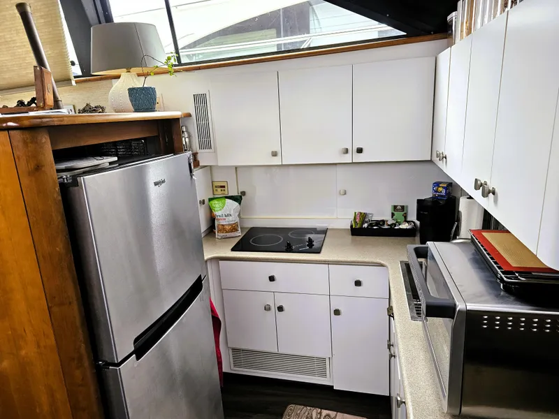 Slide: The Image of Compact kitchen in a 1995 Silverton 46 yacht with modern appliances and white cabinetry. - 13