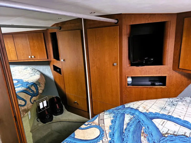 Slide: The Image of Interior of 1995 Silverton 46 yacht with wood cabinets and octopus-themed bedding. - 17