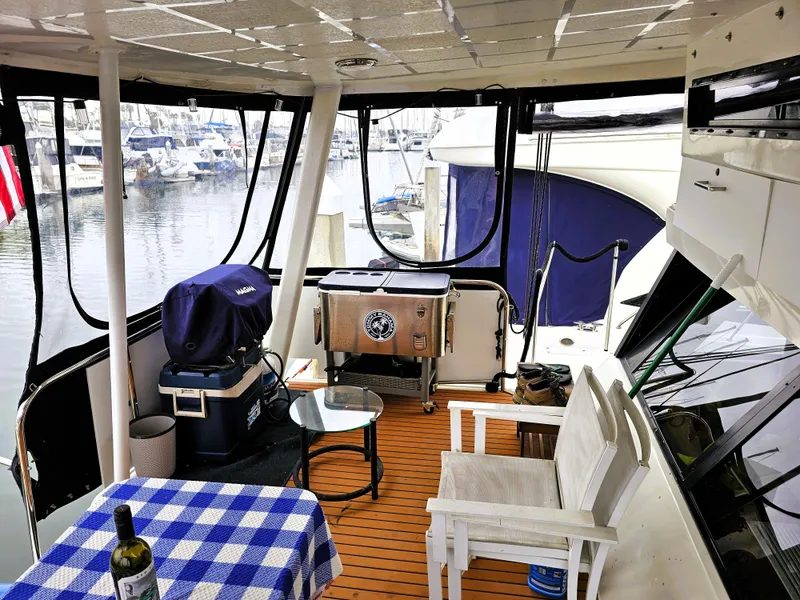 Slide: The Image of 1995 Silverton 46 yacht interior with seating, table, and marina view. - 2