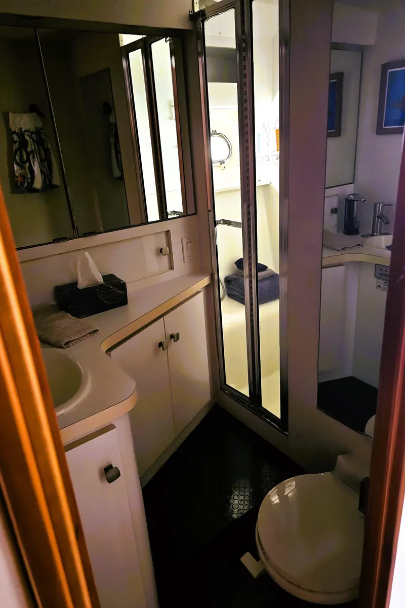 Slide: The Image of Bathroom interior of a 1995 Silverton 46 yacht, featuring a sink, mirror, and toilet. - 20