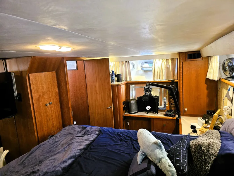 Slide: The Image of Cozy interior of a 1995 Silverton 46 yacht with wood paneling and plush bedding. - 24