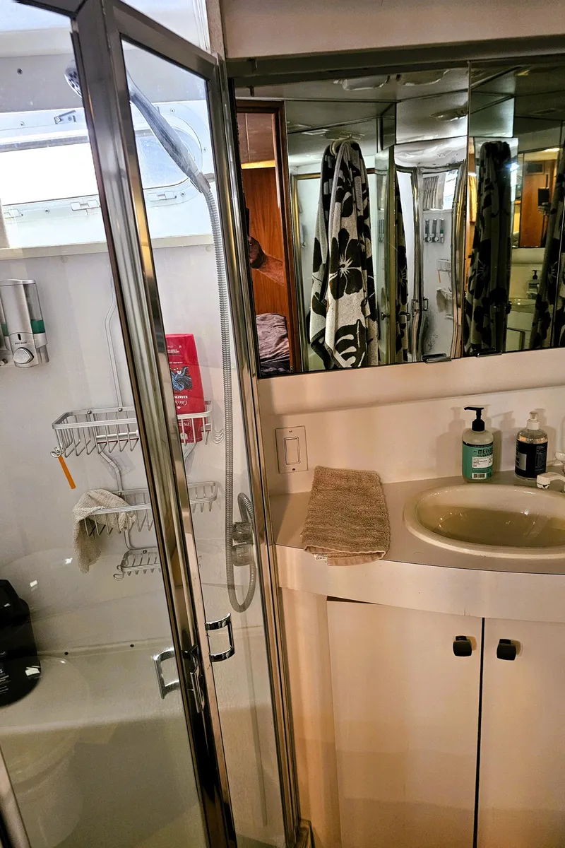 Slide: The Image of Bathroom interior of a 1995 Silverton 46 yacht, featuring a shower and sink area. - 25