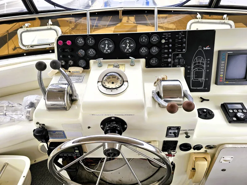 Slide: The Image of Control panel of a 1995 Silverton 46 yacht with steering wheel and navigation instruments. - 4
