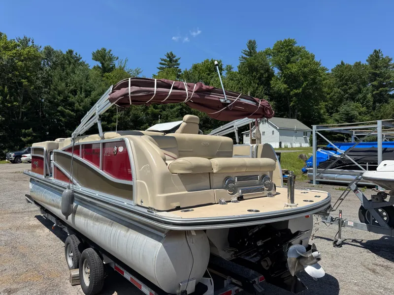 Slide: The Image of 2011 Harris Grand Mariner SEL 250 pontoon boat on trailer, parked outdoors under clear sky. - 2