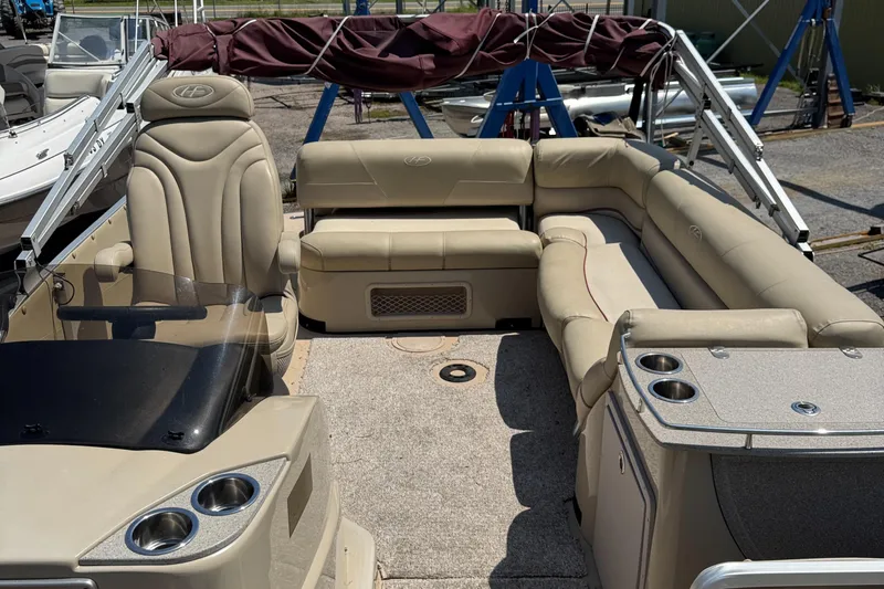Slide: The Image of 2011 Harris Grand Mariner SEL 250 pontoon boat interior with beige seating and cup holders. - 5