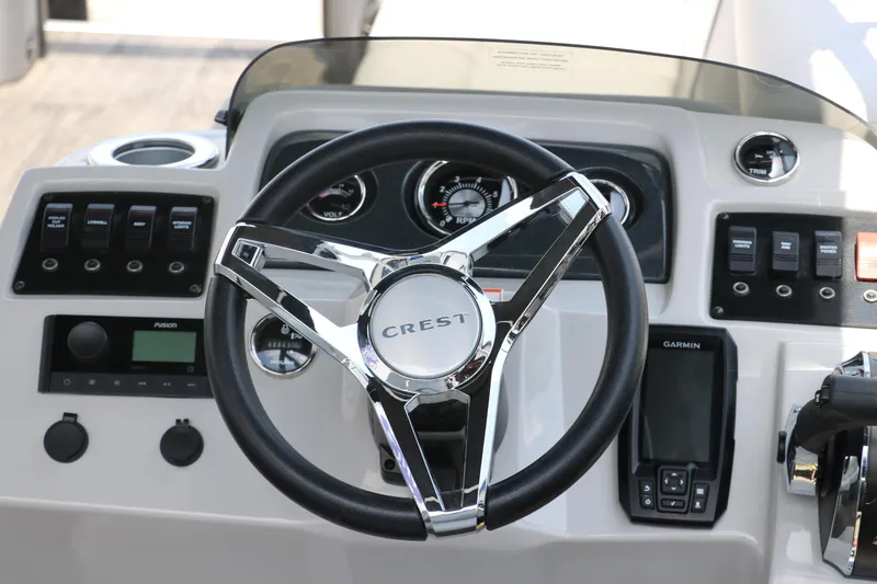 Slide: The Image of 2022 Crest Classic Fish 220 dashboard with steering wheel and control panel. - 19