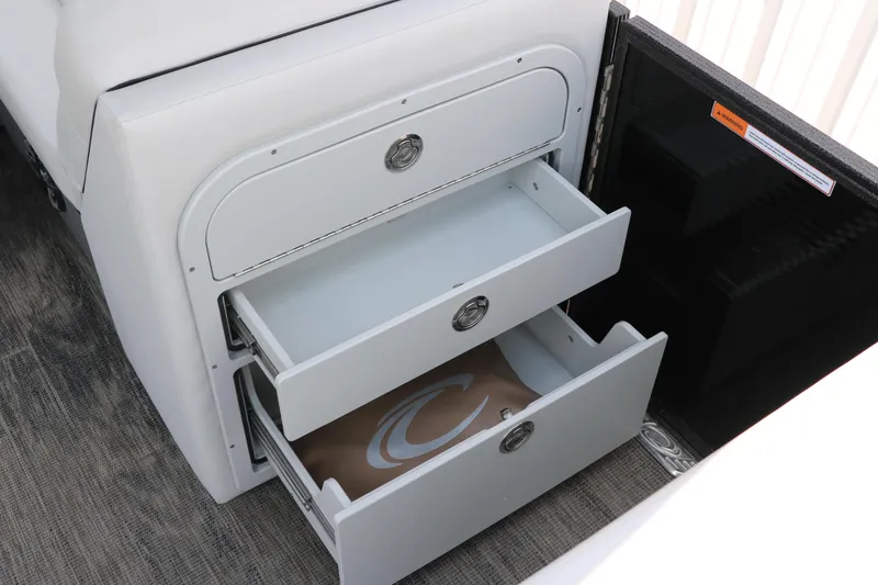 Slide: The Image of Open storage drawers in a 2022 Crest Classic Fish 220 boat interior. - 27