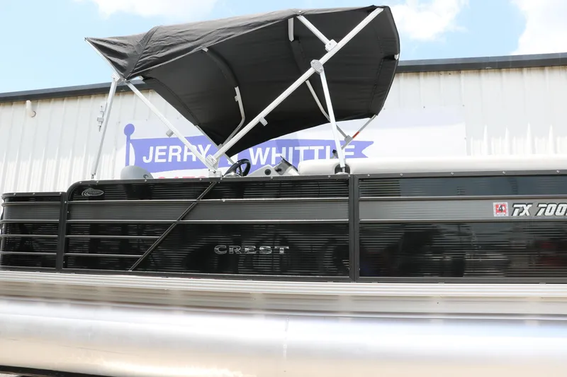 Slide: The Image of 2022 Crest Classic Fish 220 pontoon boat with canopy, displayed outdoors. - 31