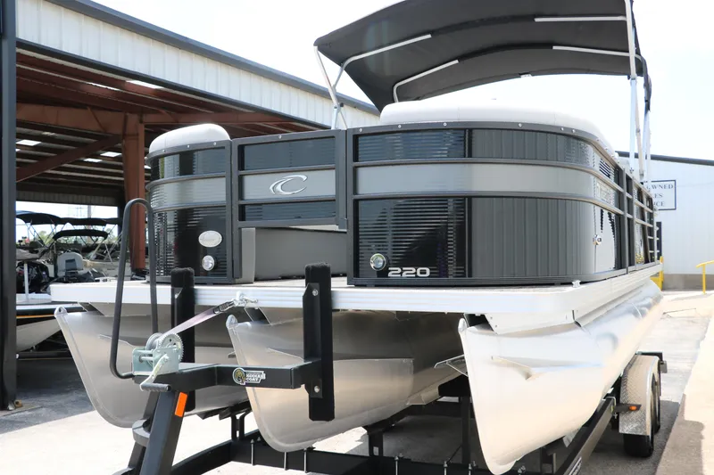 Slide: The Image of 2022 Crest Classic Fish 220 pontoon boat on trailer, parked in marina. - 9