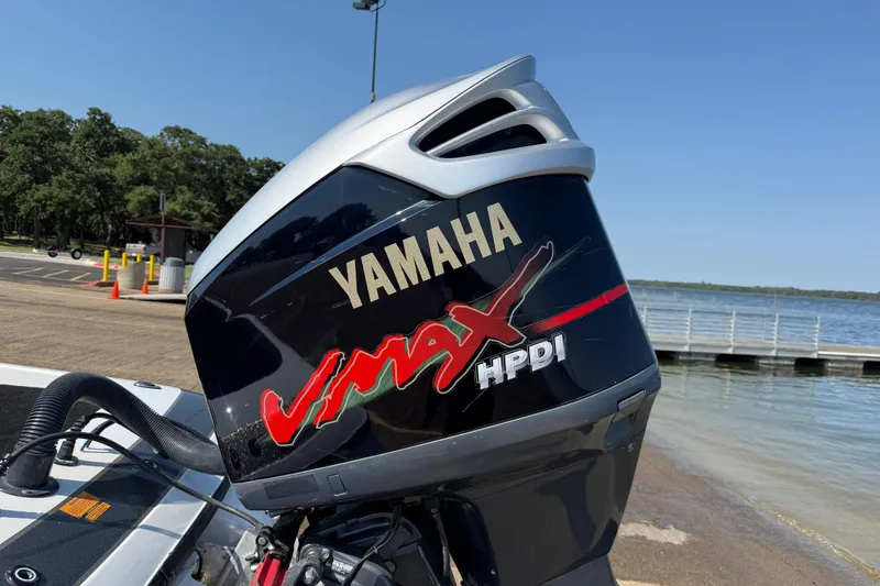Slide: The Image of Yamaha VMAX HPDI outboard motor on 2004 Skeeter ZX250 boat by a lake. - 13