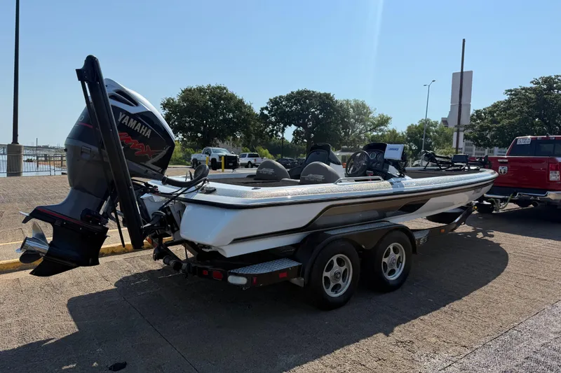 Slide: The Image of 2004 Skeeter ZX250 boat with Yamaha engine on trailer, parked near a waterfront. - 15