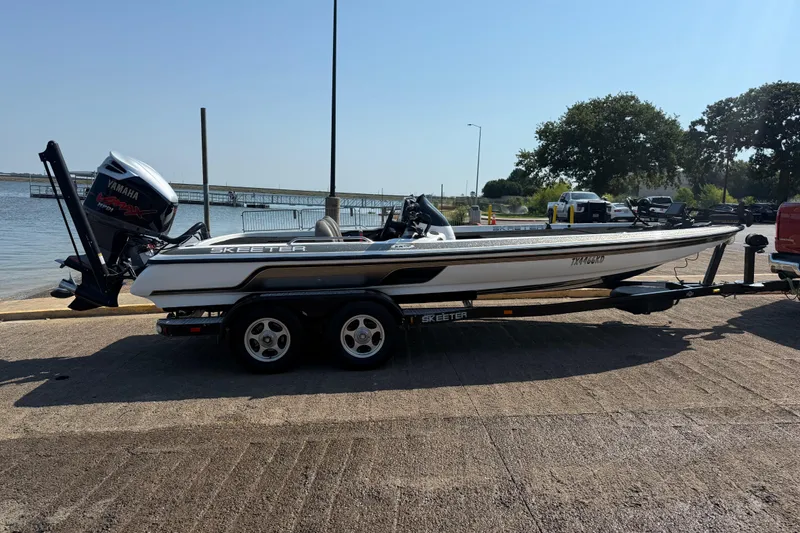 Slide: The Image of 2004 Skeeter ZX250 boat on trailer by lakeside, featuring Yamaha outboard motor. - 17