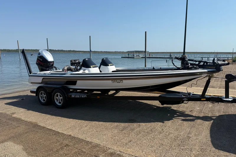 Slide: The Image of 2004 Skeeter ZX250 boat on trailer by a lake, ready for launch. - 19