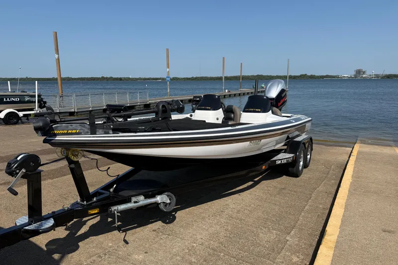 Slide: The Image of 2004 Skeeter ZX250 boat on trailer by a lake dock. - 2