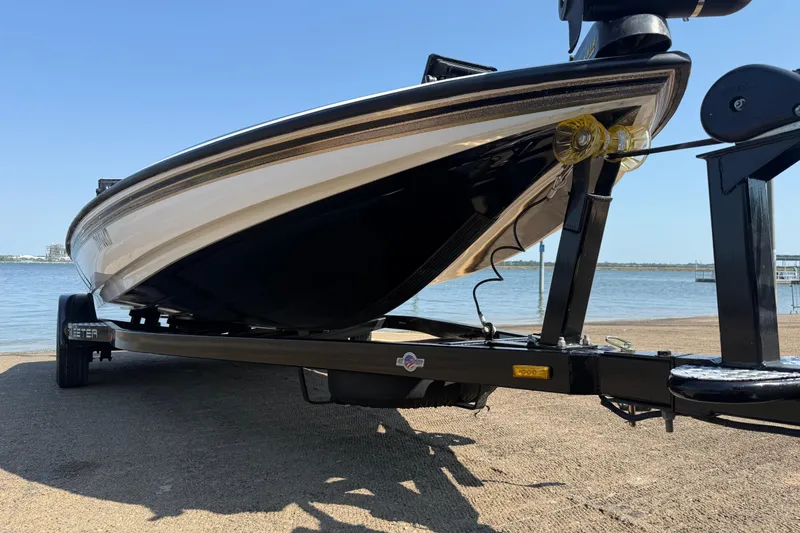 Slide: The Image of 2004 Skeeter ZX250 boat on trailer by the water, showcasing sleek design. - 22