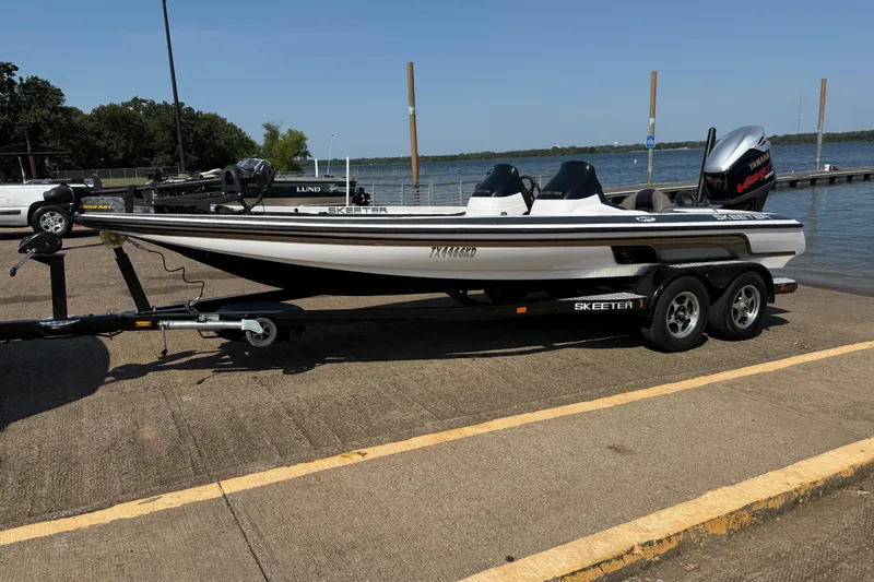 Slide: The Image of 2004 Skeeter ZX250 boat on trailer by a lake, ready for launch. - 3