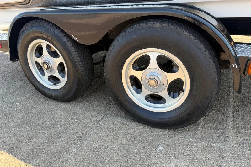Slide: The Image of 2004 Skeeter ZX250 trailer wheels on pavement, featuring dual tires and silver rims. - 34