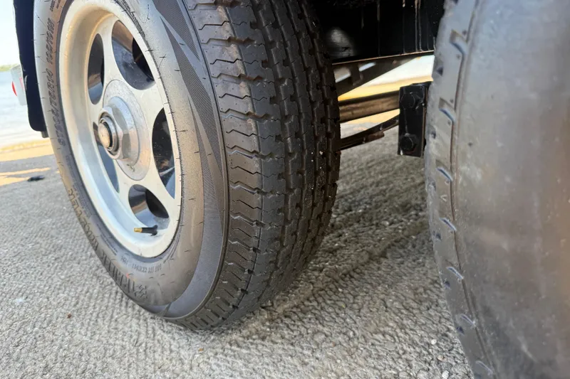 Slide: The Image of Close-up of 2004 Skeeter ZX250 trailer wheels on a textured surface. - 36