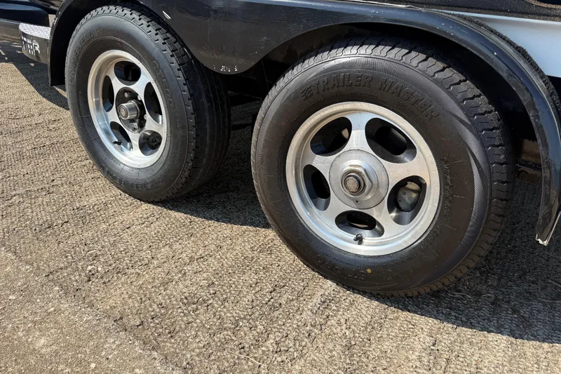 Slide: The Image of 2004 Skeeter ZX250 trailer wheels on textured pavement. - 37