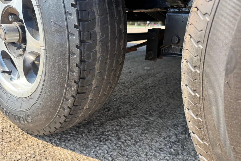 Slide: The Image of Close-up of 2004 Skeeter ZX250 trailer wheels on asphalt surface. - 38