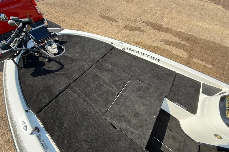 Slide: The Image of 2004 Skeeter ZX250 boat deck with trolling motor and electronics, parked on concrete. - 42