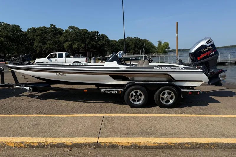 Slide: The Image of 2004 Skeeter ZX250 boat on trailer, parked near a lake with Yamaha outboard motor. - 5