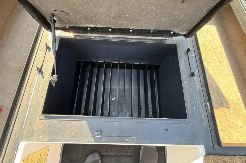 Slide: The Image of Open storage compartment in a 2004 Skeeter ZX250 boat, showing interior dividers. - 51