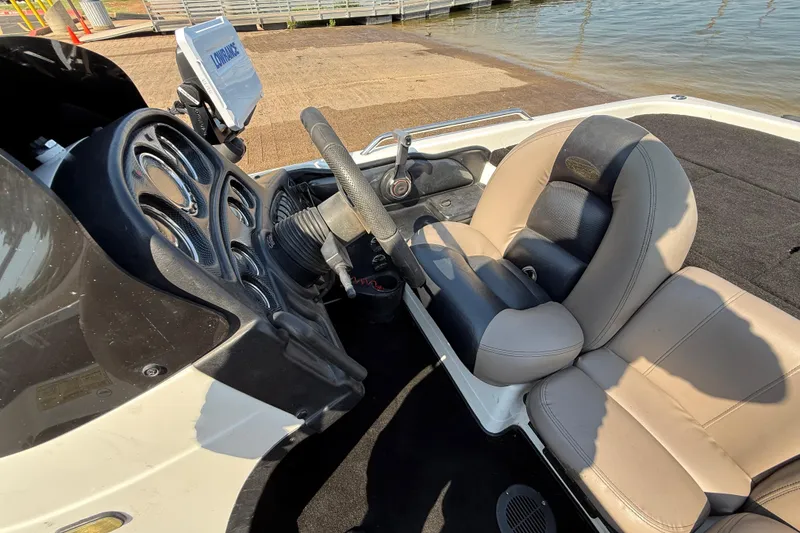 Slide: The Image of 2004 Skeeter ZX250 boat interior with steering wheel and cushioned seats near water. - 55