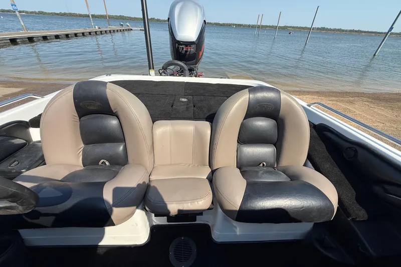 Slide: The Image of 2004 Skeeter ZX250 boat interior with dual seats by a lakeside. - 57