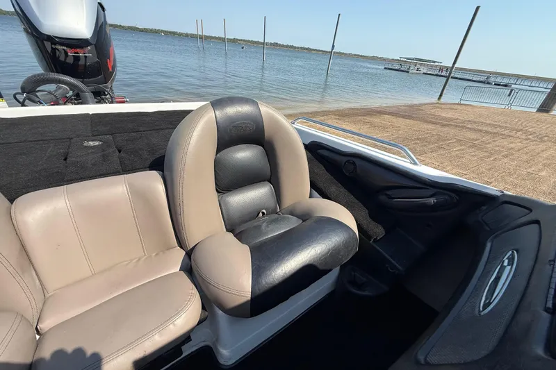 Slide: The Image of 2004 Skeeter ZX250 boat interior with leather seats by a lakeside dock. - 58
