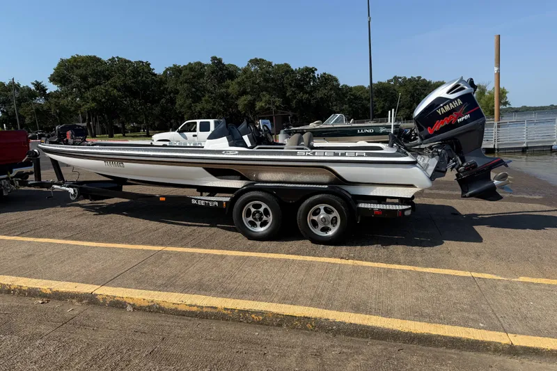 Slide: The Image of 2004 Skeeter ZX250 boat with Yamaha engine on trailer by lake. - 6