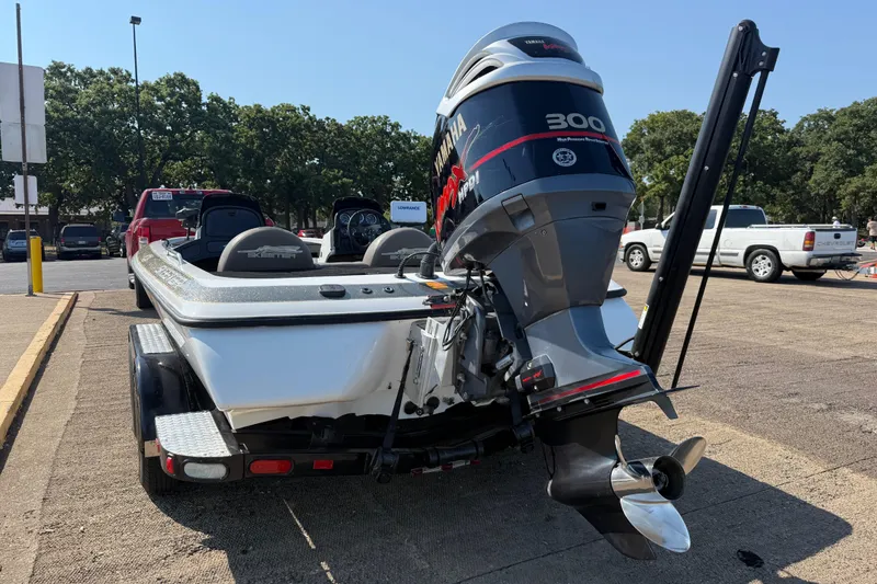 Slide: The Image of 2004 Skeeter ZX250 boat with Yamaha 300 HP engine on trailer in parking lot. - 9