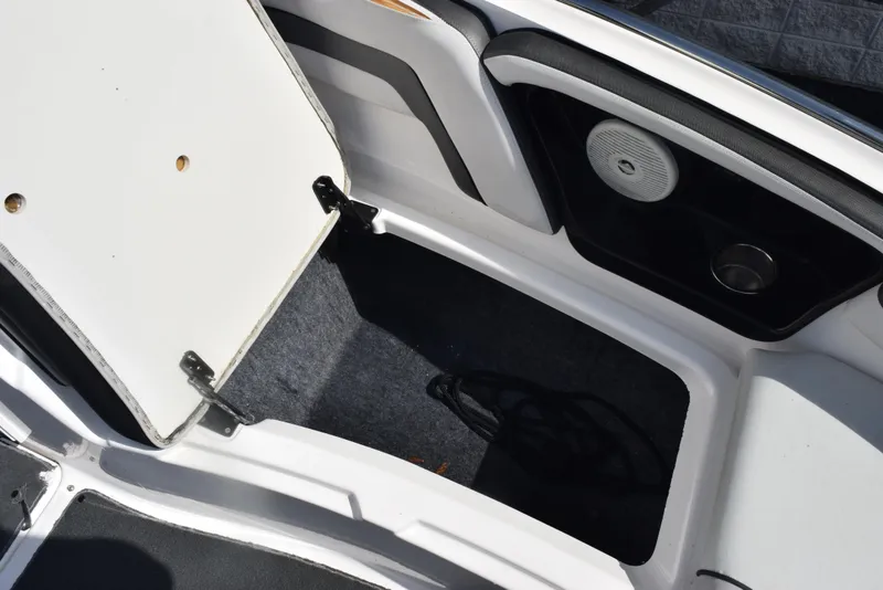 Slide: The Image of Open storage compartment in 2017 Yamaha AR240 boat, featuring speaker and cup holder. - 19