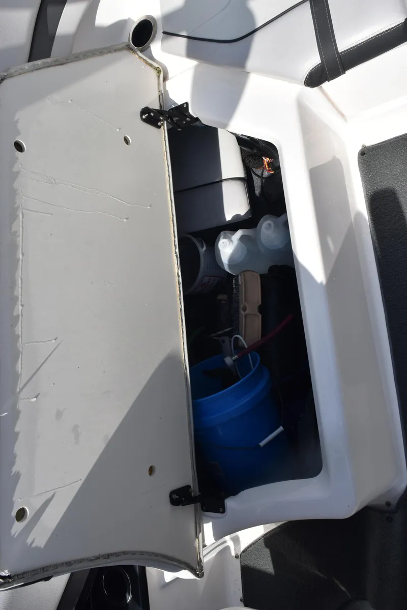 Slide: The Image of Open storage compartment on a 2017 Yamaha AR240 boat, showing interior contents. - 21