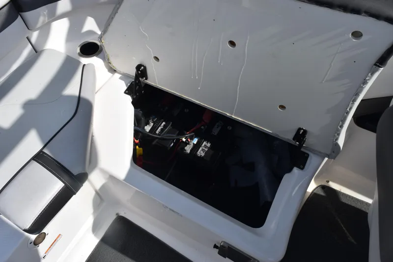 Slide: The Image of 2017 Yamaha Boats AR240 battery compartment with open hatch, showcasing interior components. - 22