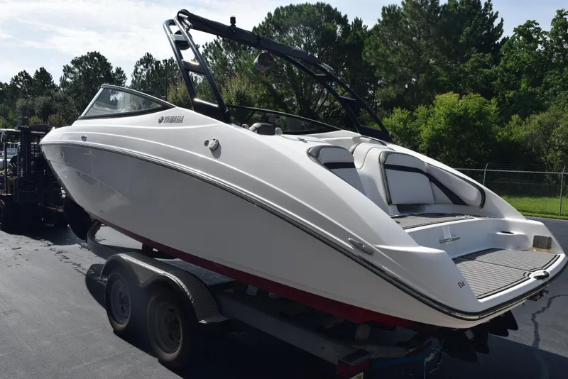 Slide: The Image of 2017 Yamaha AR240 boat on trailer, sleek design, white exterior, parked outdoors. - 6